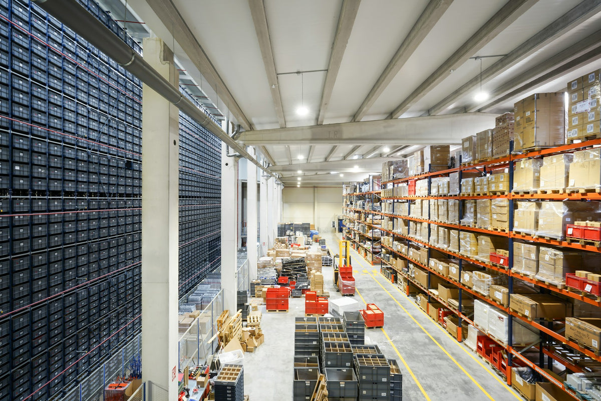 Trade parts store aisle lined with small-parts drawer cabinets and shelving.