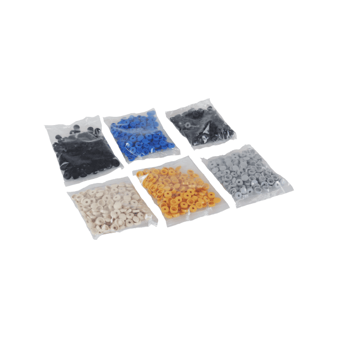 Six small clear plastic bags containing fold over screw cover caps in different colours, arranged on a white background. The colours visible are black, blue, dark gray, off-white/cream, orange, and silver.